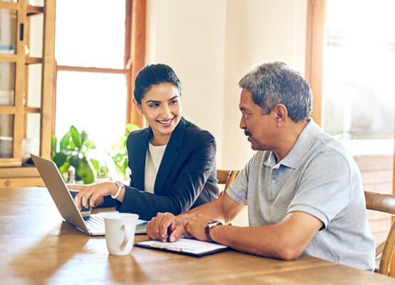 A small group of three people in a professional, relaxed setting having a focused discussion, symbolizing business consulting and strategic advice for service optimization and growth.